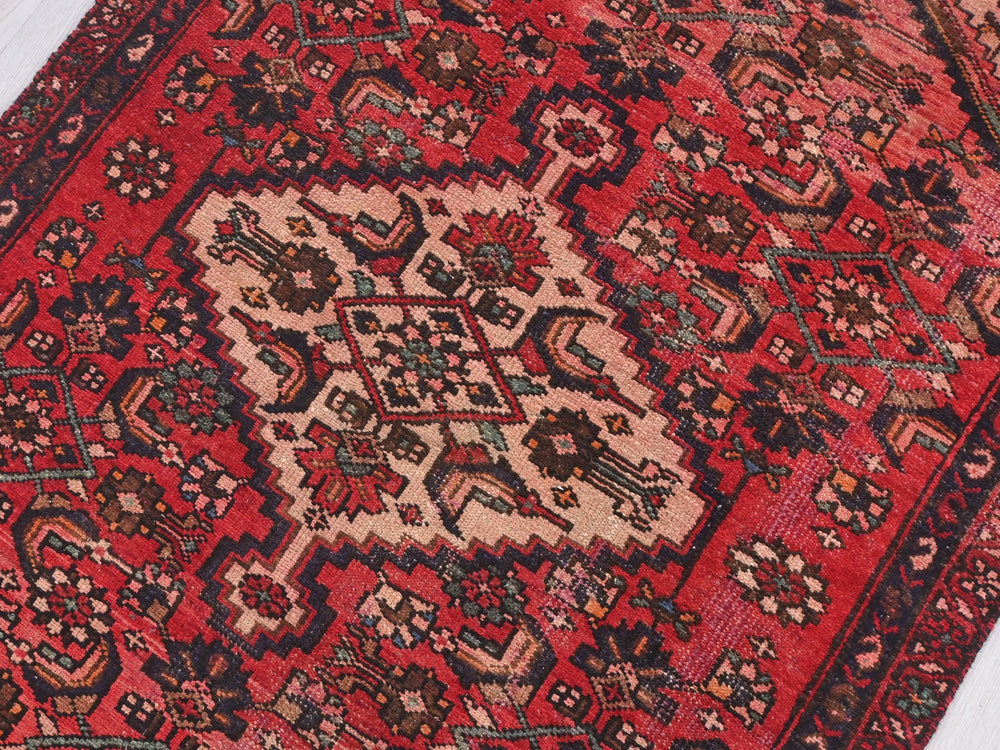 a red rug with a pattern on the middle of it