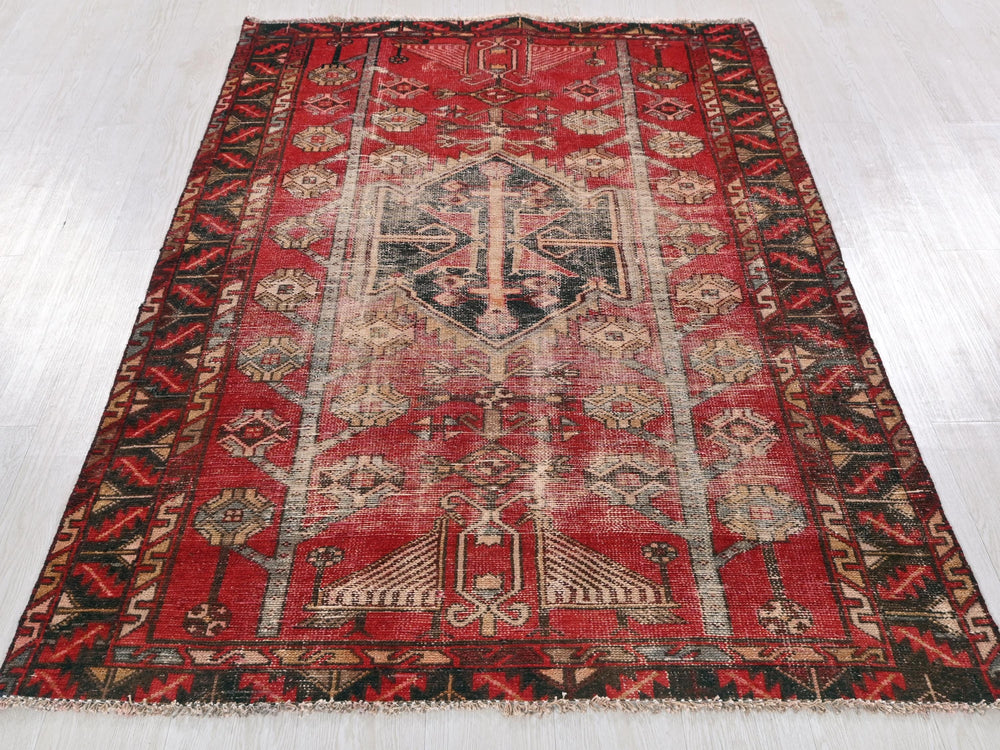 a red rug with a black border on a white floor