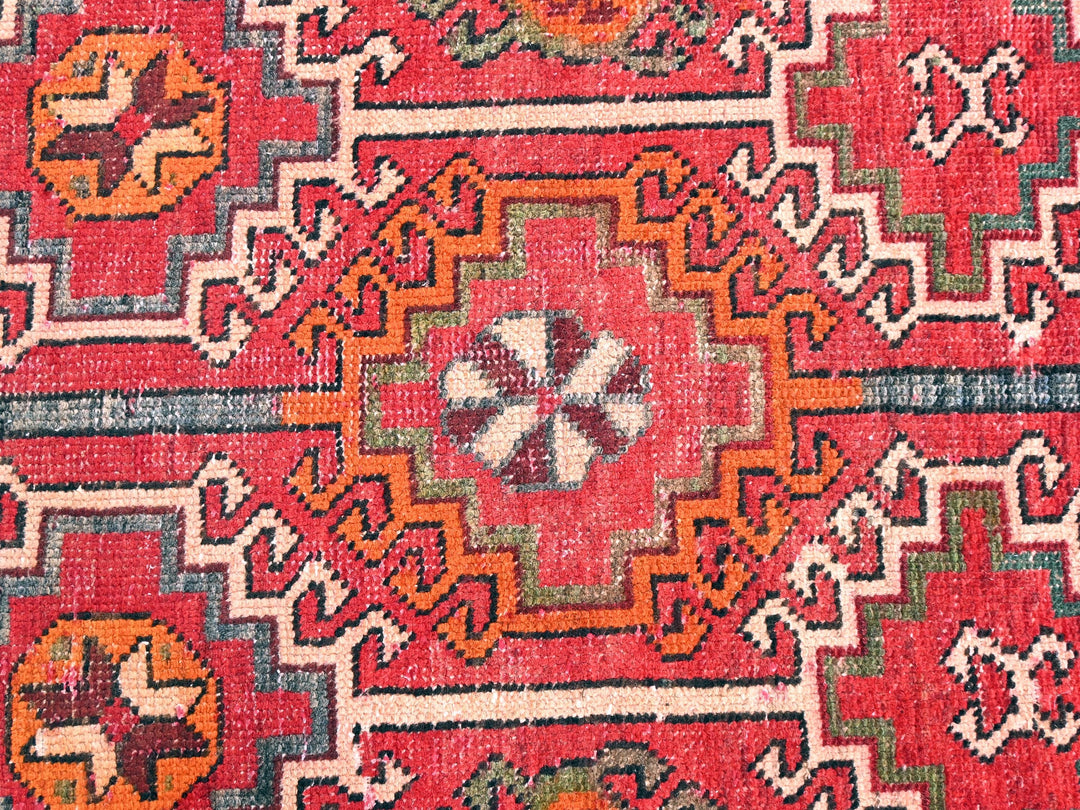 a close up of a red rug with many different colors