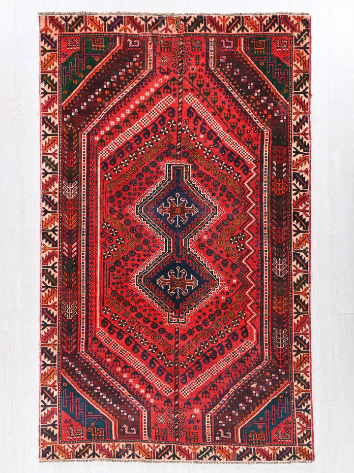 a red rug with a diamond shaped design