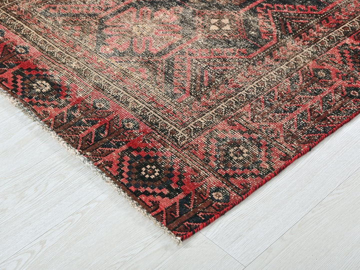 a red and black oriental rug on a white floor