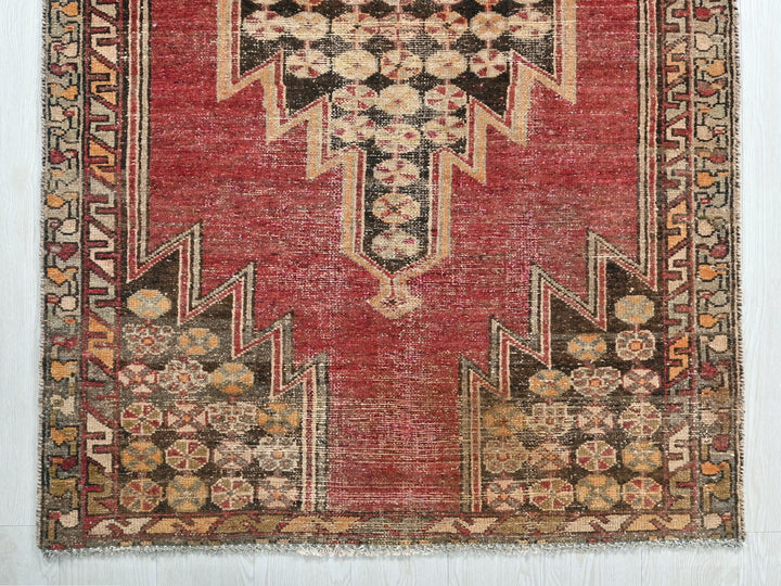a red rug with a design on the middle of it