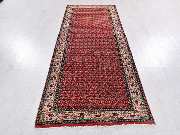 a red and black rug on a white floor