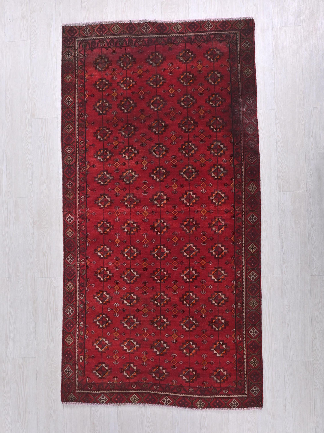 a red rug on a white wooden floor