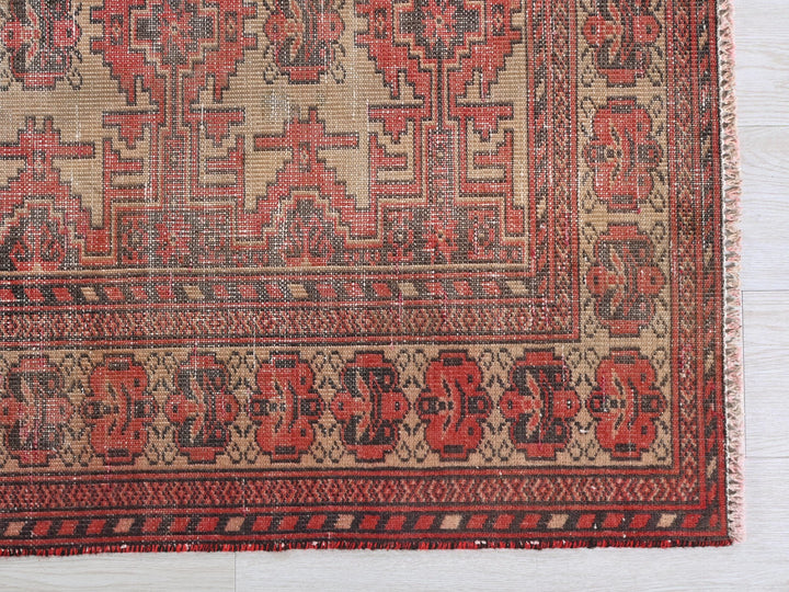 a red and beige oriental rug on a white wooden floor