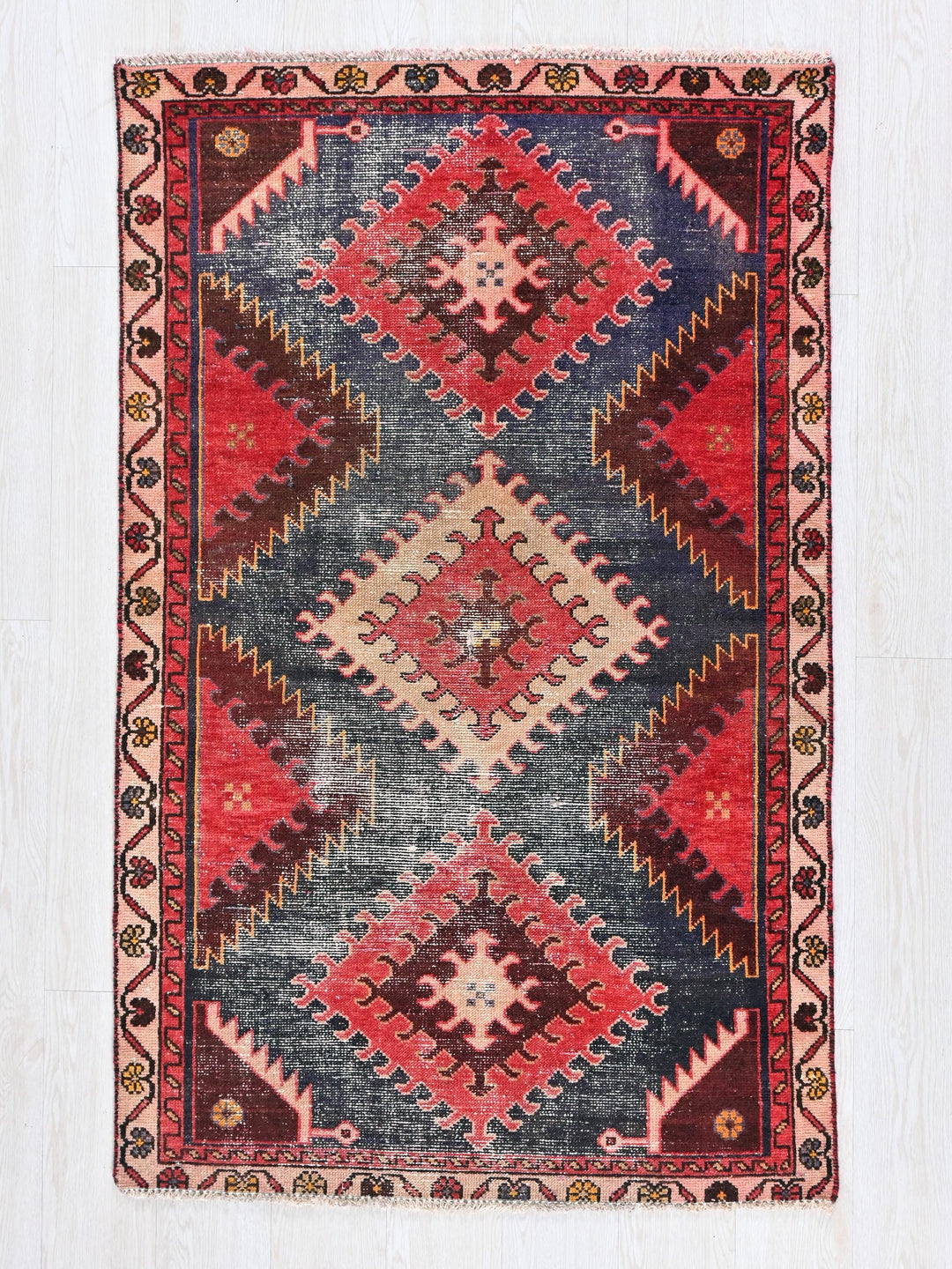 a red, blue, and black rug with a diamond pattern