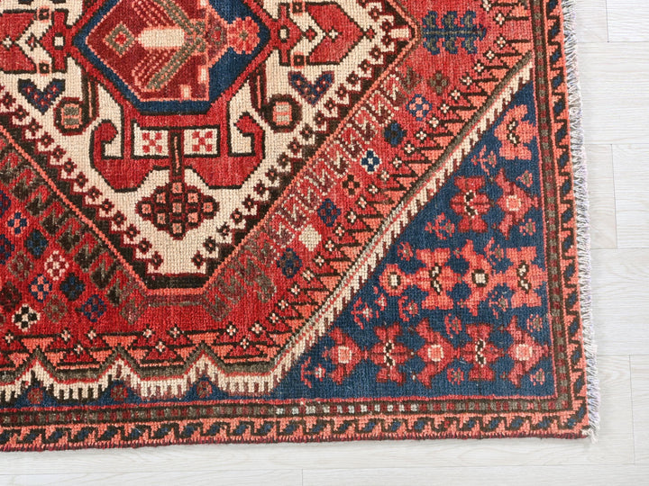 a red and blue rug on a white floor