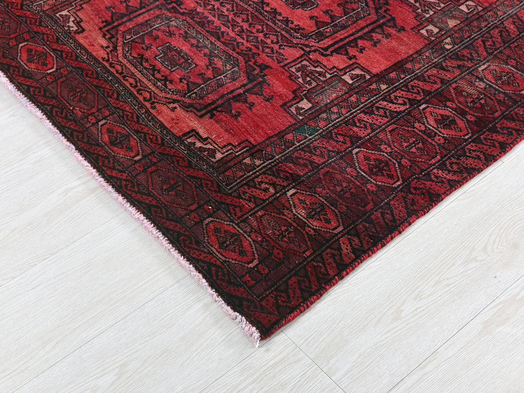 a red oriental rug on a white wooden floor