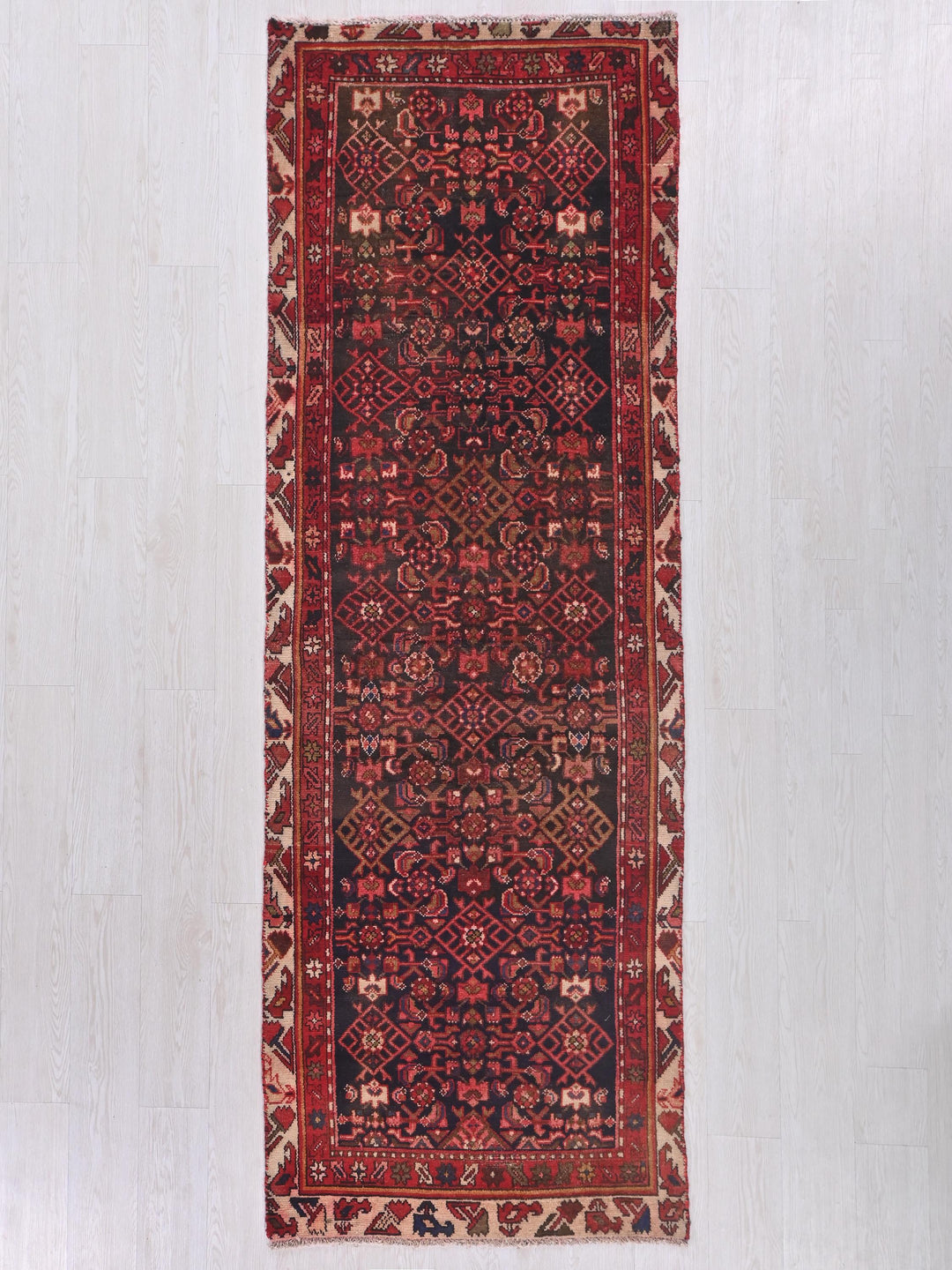 a red and black rug on a white floor