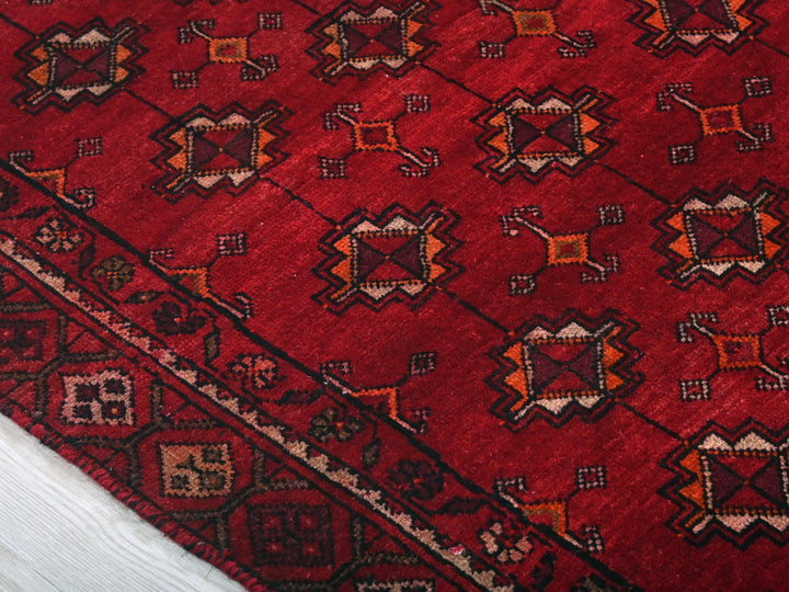a close up of a red rug on a wooden floor
