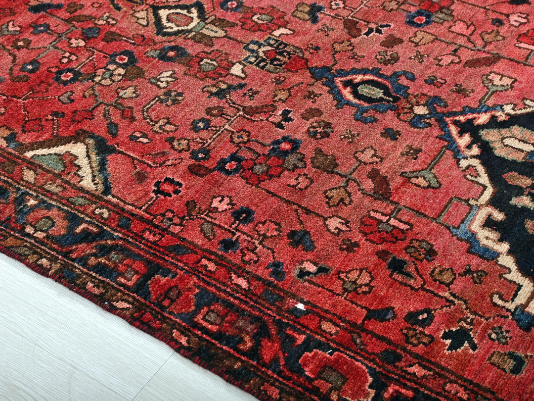 a red rug with a black and blue design on it