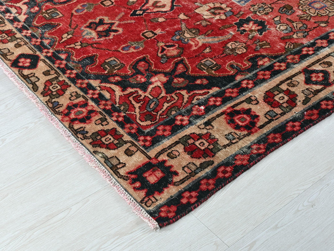 a red and black oriental rug on a white floor