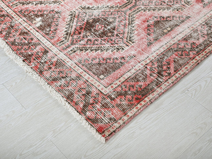 a red and brown rug on a white floor