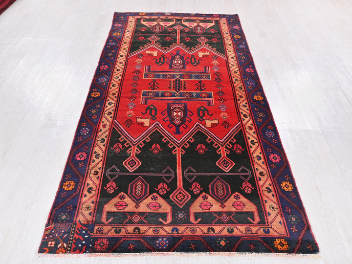 a red and black rug on a white floor