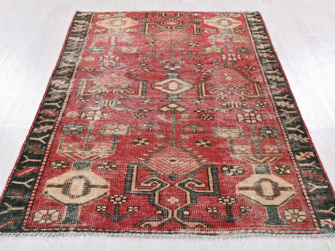 a red and black rug on a white floor
