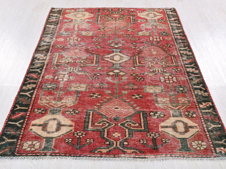 a red and black rug on a white floor