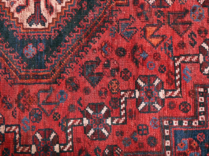 a close up of a red rug with many different designs