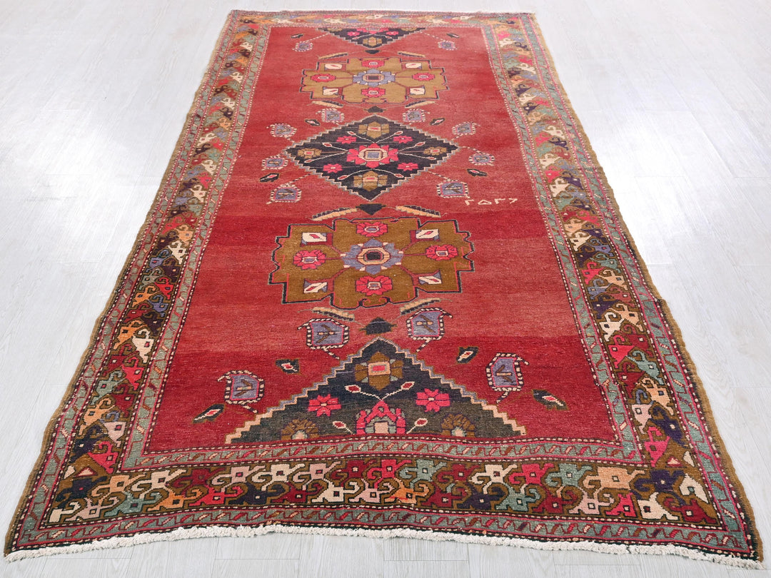 a red rug with a design on the middle of it