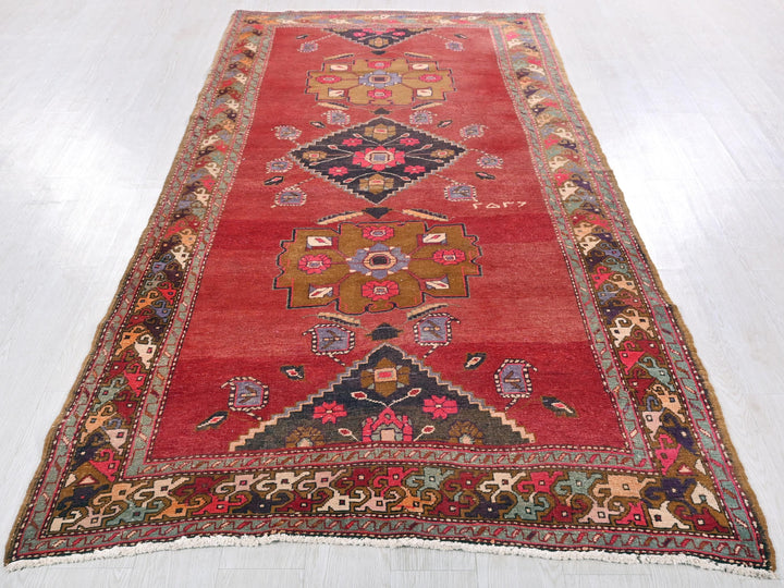a red rug with a design on the middle of it