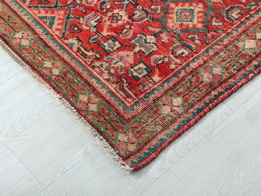 a red rug on a white wooden floor