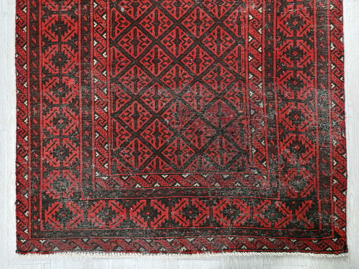 a red and black rug on a white floor