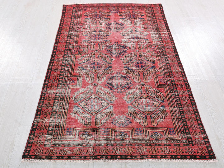 a red and black rug on a white floor