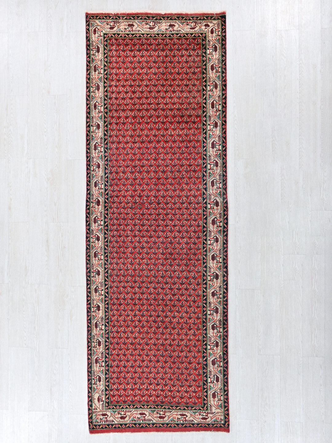 a red and black rug on a white wall