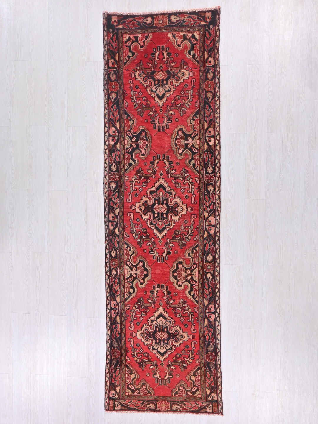 a red rug hanging on a white wall