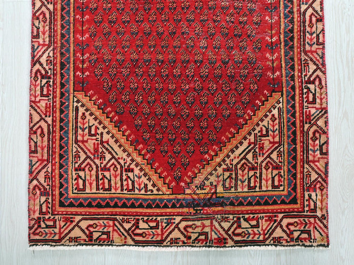 a red rug with a triangle shaped design on it