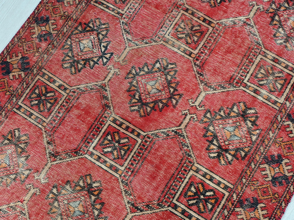 a red rug with a pattern on the middle of it