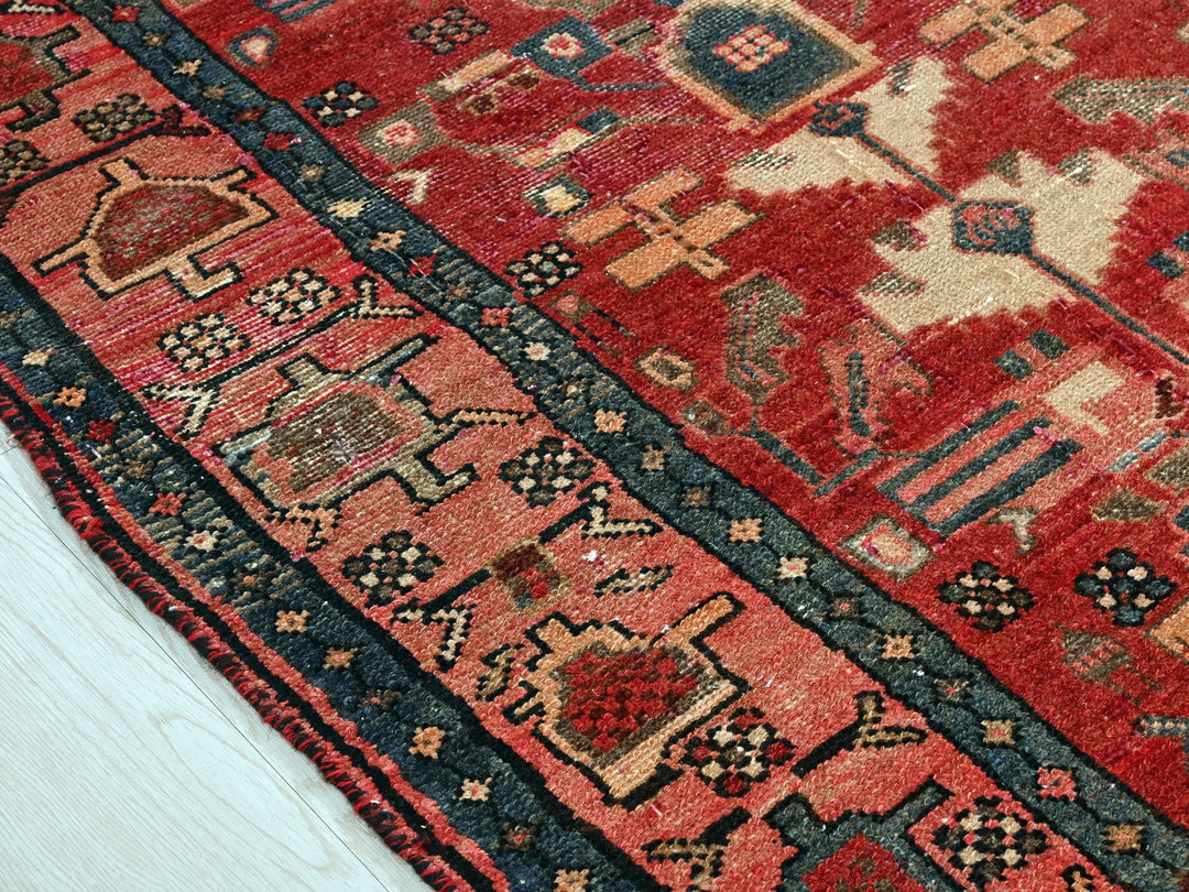 a red oriental rug on a white wooden floor