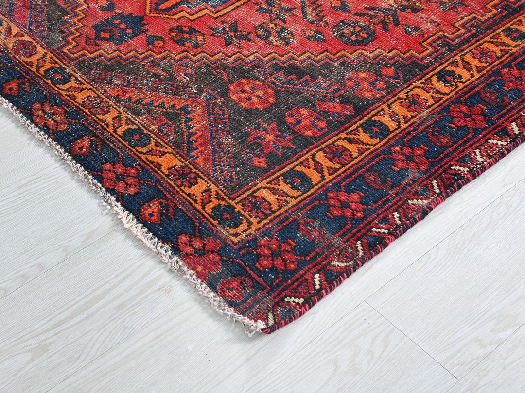 a red and blue oriental rug on a white floor