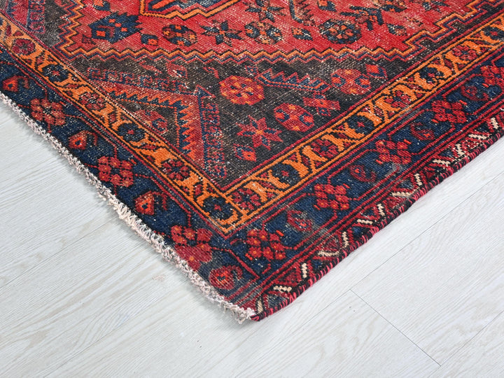a red and blue oriental rug on a white floor
