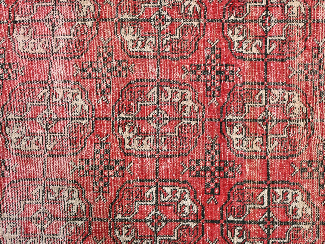 a red rug with a black and white design on it
