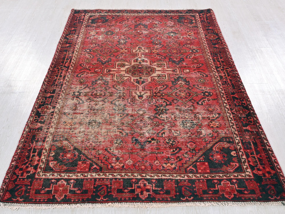 a red and black oriental rug on a white floor
