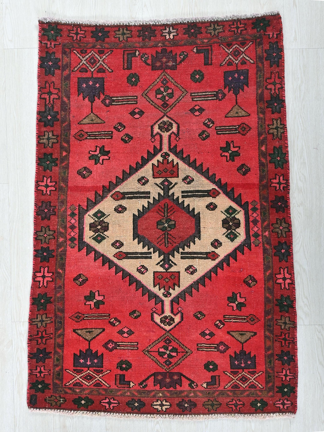 a red rug with a diamond shaped design on it