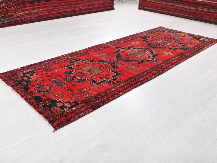 a red rug is laying on a white floor