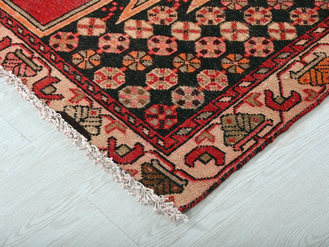 a red and black oriental rug on a white floor