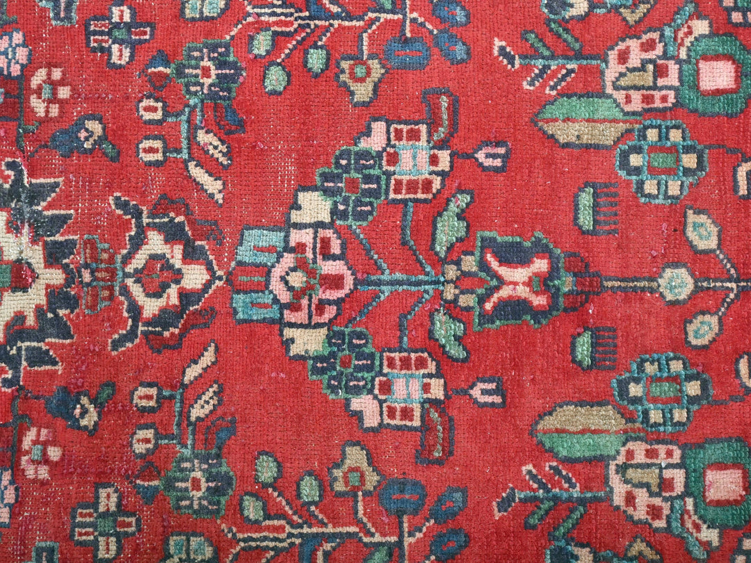 a close up of a red rug with blue and green designs