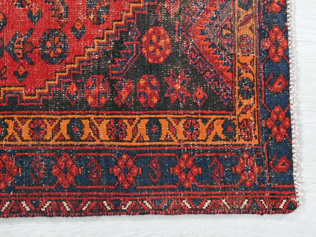 a red and blue rug on a white surface