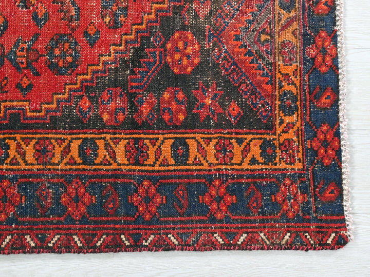 a red and blue rug on a white surface