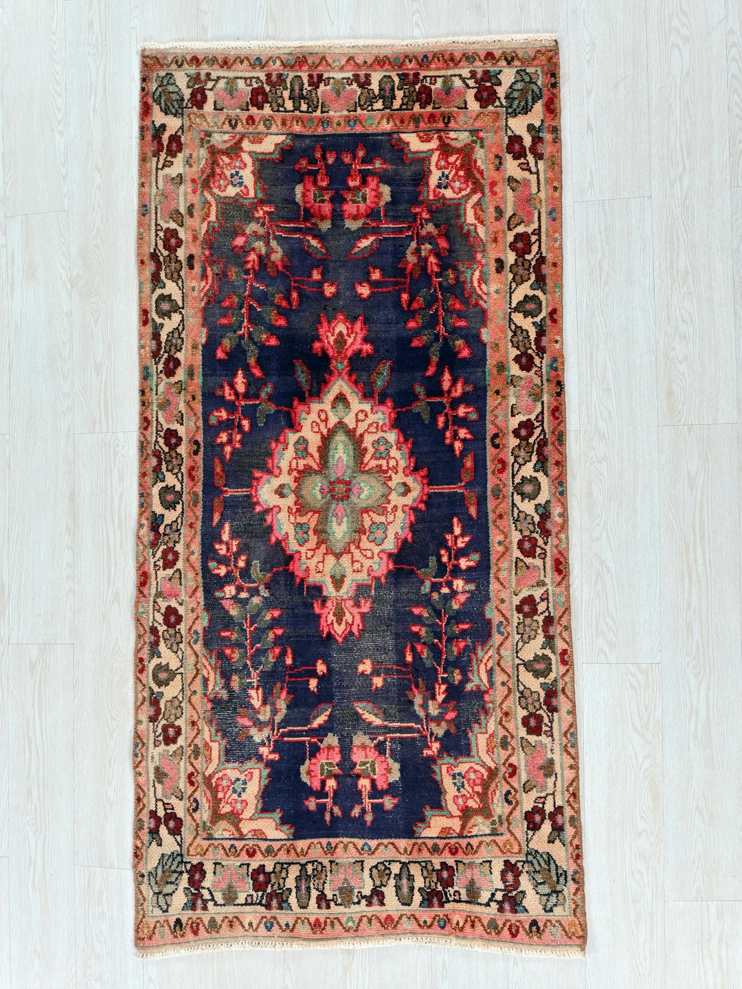 a blue and red rug on a white floor