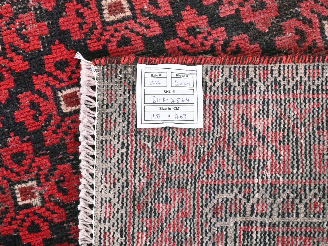 a pile of red and black rugs with a price tag