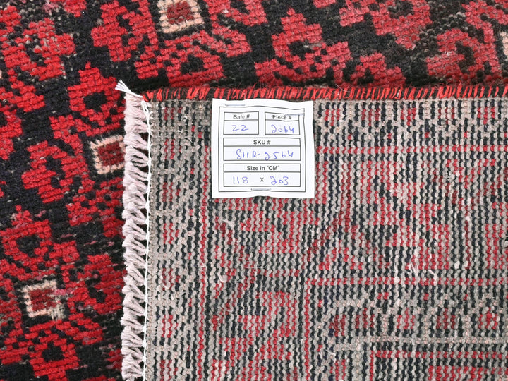 a pile of red and black rugs with a price tag