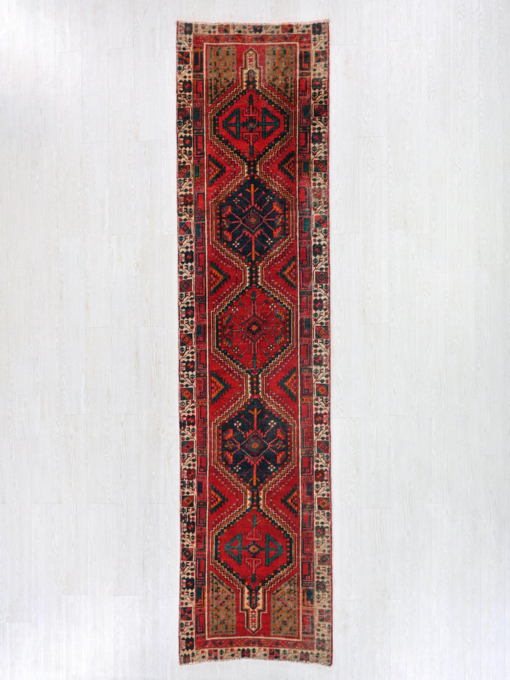 a red and blue rug hanging on a wall