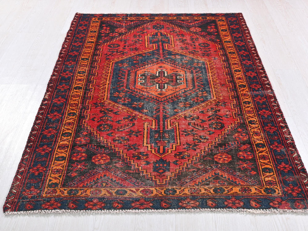 a red and blue rug on a white floor