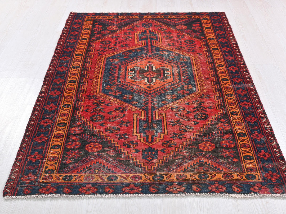 a red and blue rug on a white floor