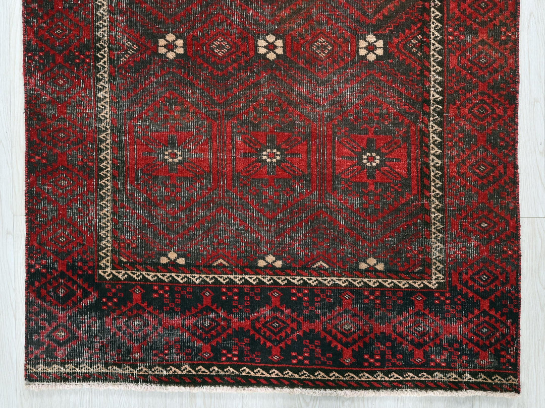 a red and black rug on a white floor