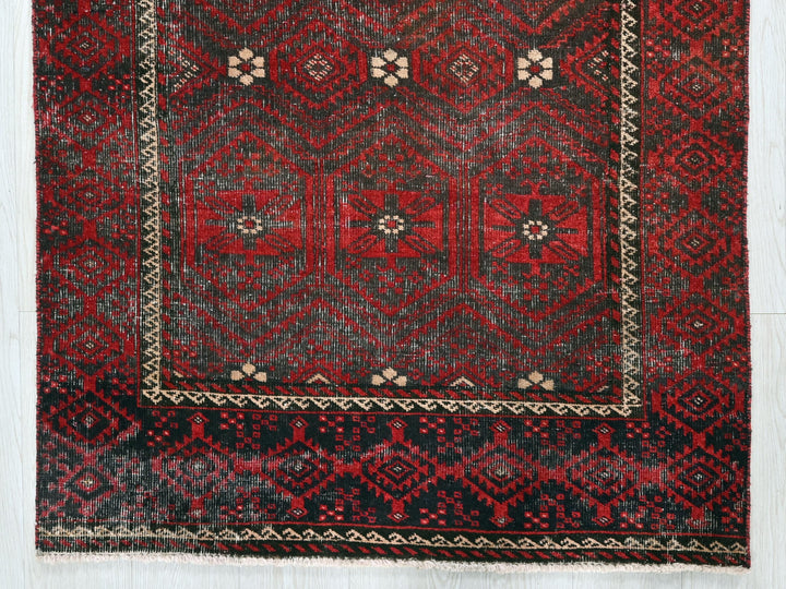 a red and black rug on a white floor