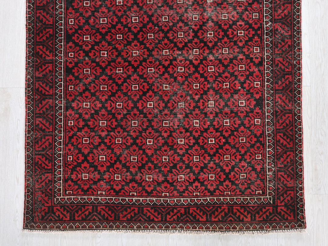 a red and black rug on a white floor